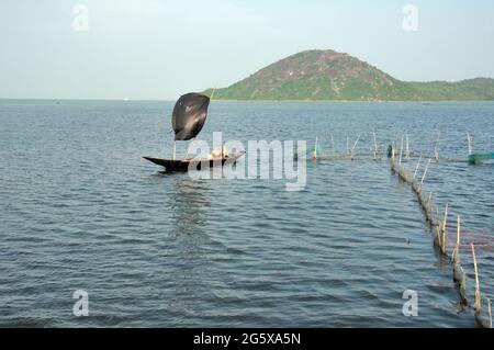 Foto del lago Chilka a Rambha, Odisha. I pescatori pescano nel lago con una barca a vela. Foto Stock