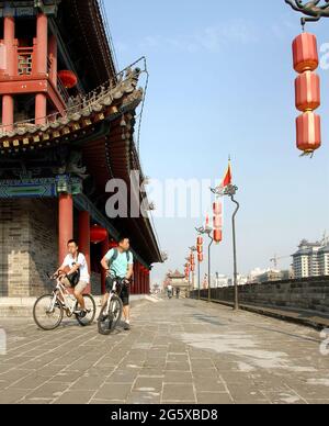 Mura cittadine, Xian, provincia di Shaanxi, Cina. Le mura cittadine di Xian sono una delle meglio conservate in Cina. La gente pedalando sulla cima delle mura della città di Xian. Foto Stock