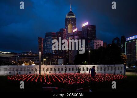 Hong Kong, Cina. 30 giugno 2021. Un lavoratore allestisce una decorazione illuminata un giorno prima delle celebrazioni del 1° luglio per celebrare gli anniversari della consegna di Hong Kong in Cina e il centesimo anno di formazione del CCP (Partito comunista cinese). Credit: SOPA Images Limited/Alamy Live News Foto Stock