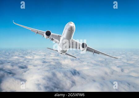 L'aereo passeggeri vola a livello di volo sullo sfondo di nuvole e di un cielo blu Foto Stock