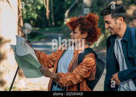 i giovani che viaggiano guardando la mappa all'aperto con zaini Foto Stock