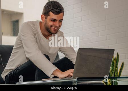 giovane uomo bearded che lavora con il laptop a casa Foto Stock