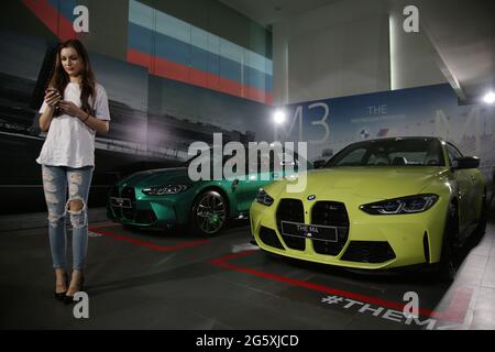 30 giugno 2021, Giacarta, Giacarta, Indonesia: I modelli si pongono tra le nuovissima BMW M3 e M4 Competition dopo un lancio virtuale a Giacarta, 30 giugno 2021. BMW Indonesia ha lanciato le due vetture con tre nuovi colori, un motore ad alte prestazioni 510hp/650nm, E un design espressivo, nonché una trasmissione BMW M Steptronic a otto velocità con Drivelogic e una serie di tecnologie innovative sviluppate dalla BMW M che saranno offerte per la nuova BMW M3 Competition al prezzo di IDR 2,059 miliardi di fuori strada, Mentre la nuova BMW M4 concorrenza Coupe sarà offerta ad un prezzo di IDR 2.119 miliardi Foto Stock