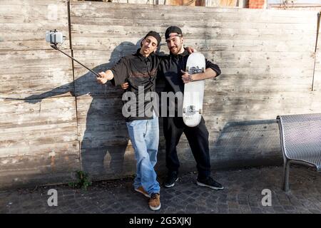 gli skateboarders dei ragazzi piccoli prendono un selfie all'aperto Foto Stock