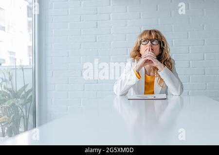 donna premurosa al tavolo da lavoro in ufficio Foto Stock