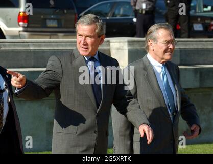 Arlington, Stati Uniti d'America. 05 ottobre 2001. Il presidente degli Stati Uniti George W. Bush è scortato a Marine One dal Segretario della Difesa degli Stati Uniti Donald Rumsfeld mentre lascia il Pentagono ad Arlington, Virginia il 24 novembre 2003 dopo la sua firma H.R. 1588, il National Defense Authorization Act dell'anno fiscale 2004.Credit: Ron Sachs/CNP/Sipa USA Credit: Sipa USA/Alamy Live News Foto Stock