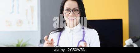 Sorridente dottore in camice bianco e stetoscopio in medicina ufficio Foto Stock
