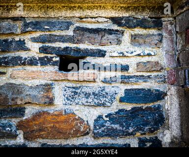 sezione di muro di ferro in un vecchio forte con un buco in esso Foto Stock