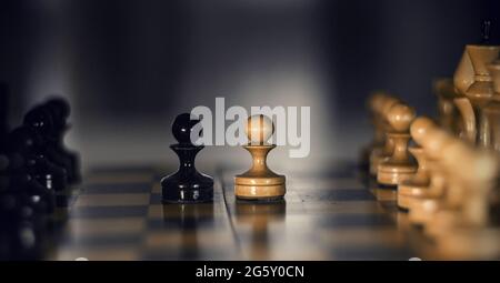 Due pezzi sulla scacchiera sono pedine: In bianco e nero. Pezzi di scacchi in legno sulla scacchiera. Gioco intellettuale - scacchi. Pezzi di scacchi sulla tavola. R Foto Stock