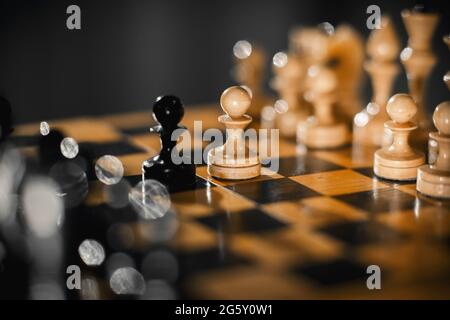 Due scacchi sono pedine: Nere e bianche. Pezzi di scacchi in legno sulla scacchiera. Gioco intellettuale - scacchi. Pezzi di scacchi sulla tavola. Un gioco di che Foto Stock