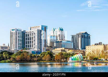Orlando, USA - 16 gennaio 2021: Vista del paesaggio urbano della città del centro della Florida nel parco del lago Eola scenografica città grattacieli edifici e sculture d'arte a. Foto Stock