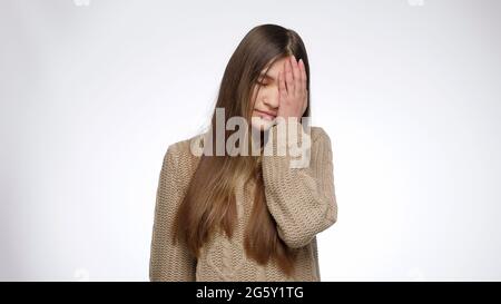 Ritratto di ragazza dispiaciuta facendo gesto facepalm. Concetto di errore ed emozione negativa Foto Stock