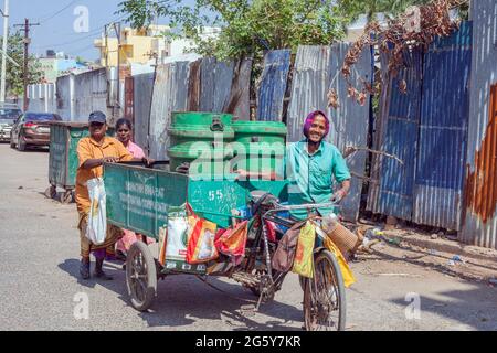 Cheerful Indian Garbage collezionisti Wheeling spazzatura cart lungo la strada, Puducherry (Pondicherry), Tamil Nadu, India Foto Stock