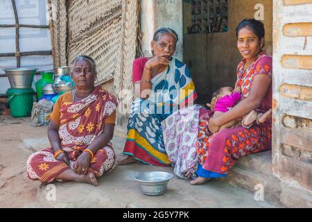 Tre femmine indù indù indiane con bindi seduti nella porta di casa in posa per foto, Puducherry (Pondicherry), Tamil Nadu, India Foto Stock