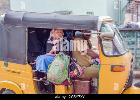Giovani femmine musulmane indiane che indossano niqab e headdress a scuola corrono in risciò auto, Puducherry (Pondicherry), Tamil Nadu, India Foto Stock