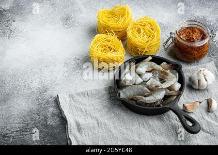 Pasta di gamberi al pesto ingredienti, su sfondo grigio in pietra, con spazio per la copia del testo Foto Stock
