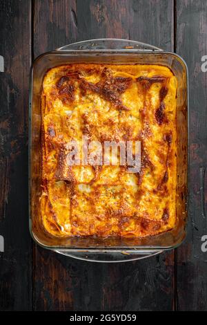 Lasagne tradizionali a base di salsa bolognese di manzo tritato con foglie di basilico, in teglia, su vecchio sfondo di legno scuro, vista dall'alto, piatto Foto Stock