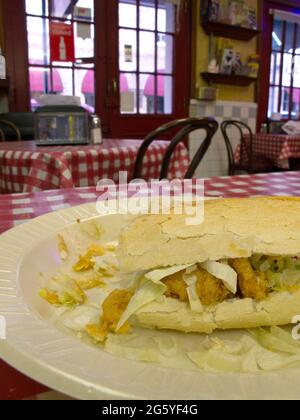 Un po'boy di gamberi si trova all'interno di un ristorante po-Boy. Foto Stock