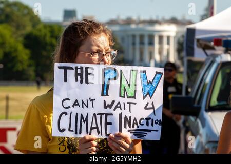 Washington, DC, Stati Uniti. 30 giugno 2021. Nella foto: Makayla Long di GreenFaith tiene un cartello all'esterno della Casa Bianca che fa riferimento al ruolo del cambiamento climatico nell'ondata di caldo senza precedenti che attualmente colpisce il Pacifico nord-occidentale. I manifestanti hanno bloccato l’ingresso alla Casa Bianca in una protesta che invita l’amministrazione e il Congresso di Biden a dare priorità alla giustizia climatica e ai diritti indigeni e a fermare l’ulteriore sviluppo dell’estrazione dei combustibili fossili. Credit: Alison Bailey/Alamy Live News Foto Stock