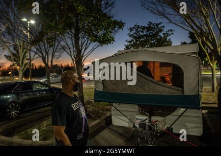 Sacramento, California, Stati Uniti. 17 gennaio 2021. Mentre il sole tramonta Anthony, 45 anni, guarda la sua famiglia in un camper dopo che sabato 17 gennaio 2021 non hanno potuto pagare un'altra notte al Fairfield Inn. Sono una delle 1,148 famiglie senza tetto che vivono a Sacramento, secondo un nuovo rapporto del Dipartimento degli alloggi e dello sviluppo urbano degli Stati Uniti pubblicato questa primavera. Il numero è salito da 1,132 un anno prima, riflettendo le difficoltà di alloggi di famiglie stabilite qui. (Credit Image: © Renee C. Byer/The Sacramento Bee/ZUMA Press Wire) Foto Stock