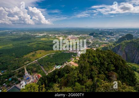 Vista dalla scogliera al tempio di Tiger Cave e campi verdi. Piccole case in lontananza. Nuvole nel cielo blu. Foto Stock