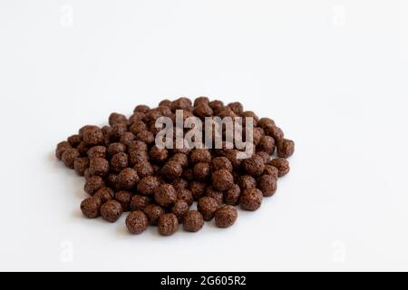 palle croccanti di cereali al cioccolato isolate su sfondo bianco, palle secche aromatizzate al cioccolato per colazione Foto Stock