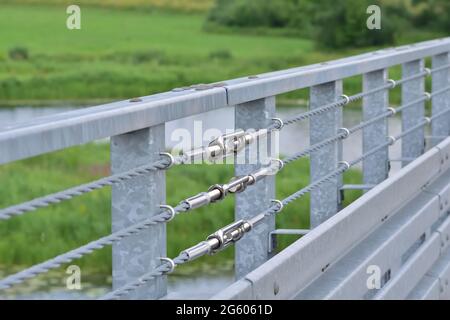 Barriera per funi sul ponte e tenditore per la regolazione. Estate. Foto Stock