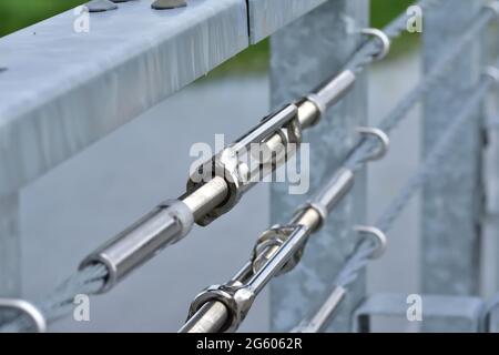 Barriera per funi sul ponte e tenditore per la regolazione. Estate. Foto Stock