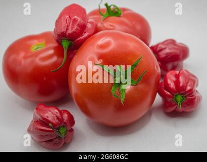 Pomodori con peperoni rossi isolati su sfondo bianco Foto Stock