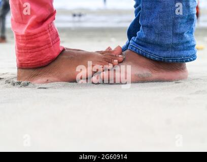 Giovane coppia baciando all'aperto in estate sulla spiaggia di mare. Due persone sulla spiaggia. Foto Stock