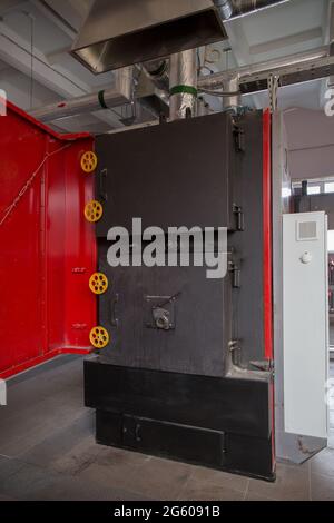 Una caldaia per il riscaldamento dei locali di una fabbrica di trattamento dei rifiuti. La caldaia funziona su rifiuti combustibili. Foto Stock