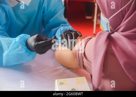 Indonesia. 01 luglio 2021. Una donna riceve un vaccino contro il Sinovac COVID-19 durante una vaccinazione di massa allo stadio Patriot Candrabaga di Bekasi, Jawa Barat, Indonesia, giovedì, luglio 1, 2021. Il quarto paese al mondo più popoloso, ha visto l'aumento delle infezioni da COVID-19 nelle ultime settimane, esercitando pressioni sugli ospedali, anche nella capitale, dove la maggior parte dei letti ospedalieri sono pieni. (Foto di Ahmad Soleh/Sipa USA) Credit: Sipa USA/Alamy Live News Foto Stock