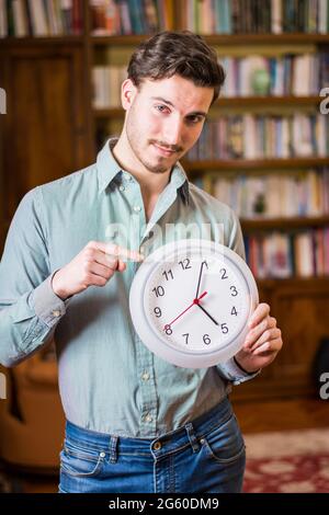 Giovane uomo ha paura del tempo di orologio di contenimento Foto Stock