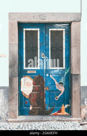 Affresco dipinto sulle porte nella stretta strada acciottolata Rua de Santa Maria nel centro storico di Funchal, isola di Madeira, Portogallo Foto Stock