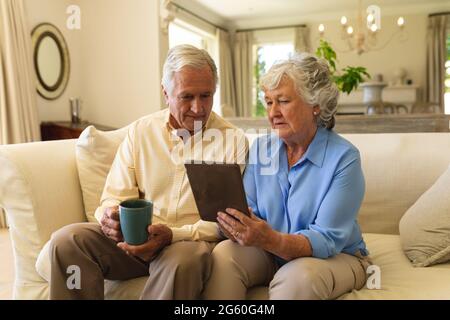 Coppia caucasica senior seduta sul divano utilizzando un tablet Foto Stock