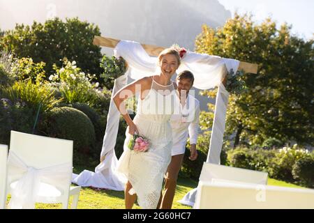 Felice sposa caucasica e sposo sposarsi e sorridere Foto Stock