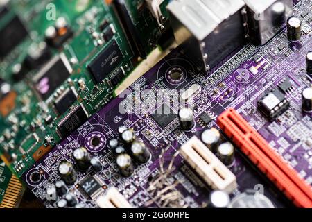 Immagine ravvicinata delle schede a circuito stampato prese dai vecchi computer desktop PC. L'immagine mostra i componenti elettronici saldati su piastre cuircuit colorate. Foto Stock