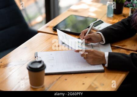 Donna d'affari che discute le tabelle e i grafici che mostrano i risultati del loro lavoro di squadra riuscito, concetto finanziario di contabilità Foto Stock