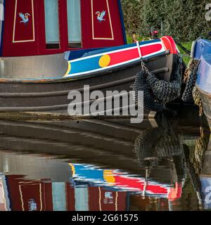 Riflessi colorati di una narrowboat nel canale di Leeds a Liverpool nel North Yorkshire Foto Stock