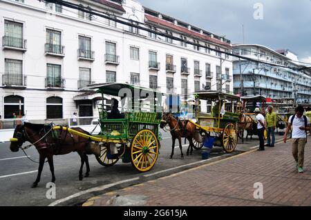 Filippino si siede a bordo di carrozze trainate da cavalli e in attesa per le persone filippine e stranieri utilizzano il servizio di viaggio Visita il tour di Piazza Intramuros a maggio Foto Stock