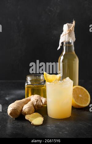 Kombucha biologico fatto in casa con miele, limone e zenzero su sfondo nero. Formato verticale. Primo piano. Foto Stock