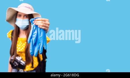 Banner, formato lungo. Donna turistica in maschera di faccia che tiene guanti medici per proteggersi dal virus. Foto Stock