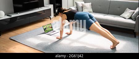 Donna che fa l'allenamento in linea di idoneità a casa Foto Stock