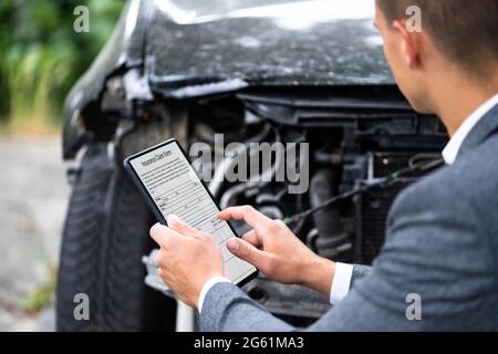 Agente assicurativo che ispetta l'automobile danneggiata con il tablet digitale Foto Stock