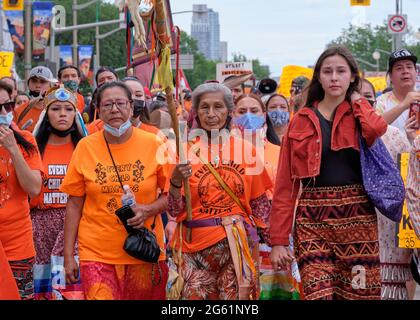 Ottawa, Canada. 1 luglio 2021. Tre generazioni di madrelingua che conducono via come migliaia di marzo attraverso la strada della capitale in un Rally Cancel Canada guidato da leader indigeni che chiedono ai canadesi di ripensare la festa nazionale come il Canada continua a aggrapparsi con l'eredità delle scuole residenziali indiane come più dei corpi dei bambini vengono scoperti in tombe non marcate. Orange è stato indossato in memoria di questi bambini che sono morti in scuole residenziali in tutto il paese. Credit: Meanderingemu/Alamy Live News Foto Stock