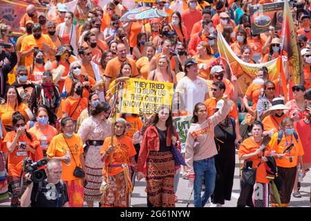 Ottawa, Canada. 1 luglio 2021. Migliaia di persone hanno marciato per la strada della capitale in un Rally Cancel Canada guidato da leader indigeni che chiedono ai canadesi di ripensare la festa nazionale, mentre il Canada continua a cimentarsi con l'eredità delle scuole residenziali indiane, mentre più corpi dei bambini vengono scoperti in tombe non marcate. Orange è stato indossato in memoria di questi bambini che sono morti in scuole residenziali in tutto il paese. Credit: Meanderingemu/Alamy Live News Foto Stock