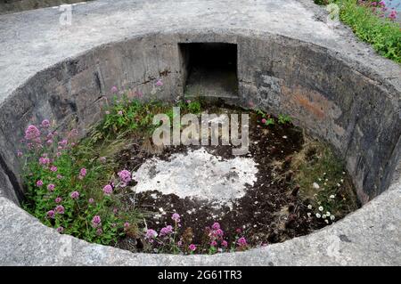 Resti di una arma della seconda guerra mondiale, ambientato nella parete rocciosa, presso il sito di Brownstone Emergency Battery a Froward Point vicino a Kingsmere, Devon. Foto Stock