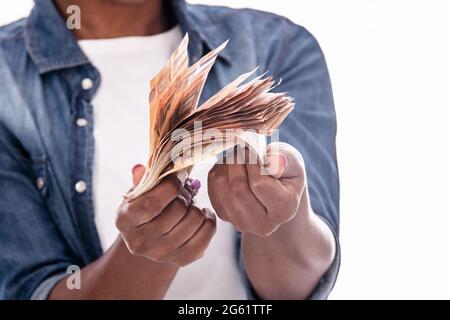 Primo piano di bollette di denaro detenute dalle mani di donna africana: Concetto di denaro Foto Stock