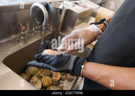 Brooklyn, New York, Stati Uniti. 30 giugno 2021. Persona che scopa le vongole fresche. Brooklyn, New York. 20210630. NEW Credit: Edna Leshowitz/ZUMA Wire/Alamy Live News Foto Stock