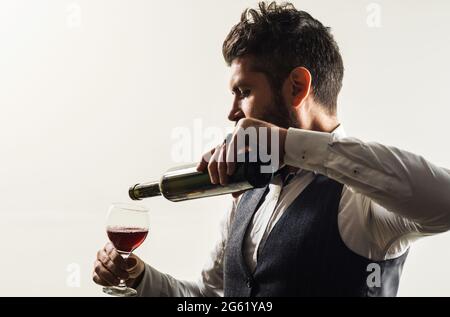 Uomo bearded con bottiglia e bicchiere di vino. Sommelier degustazione di vino nel ristorante. Degustazione di alcol. Foto Stock